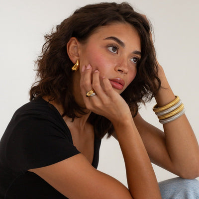 model wearing mixed metals cross over ring and snake bracelets 