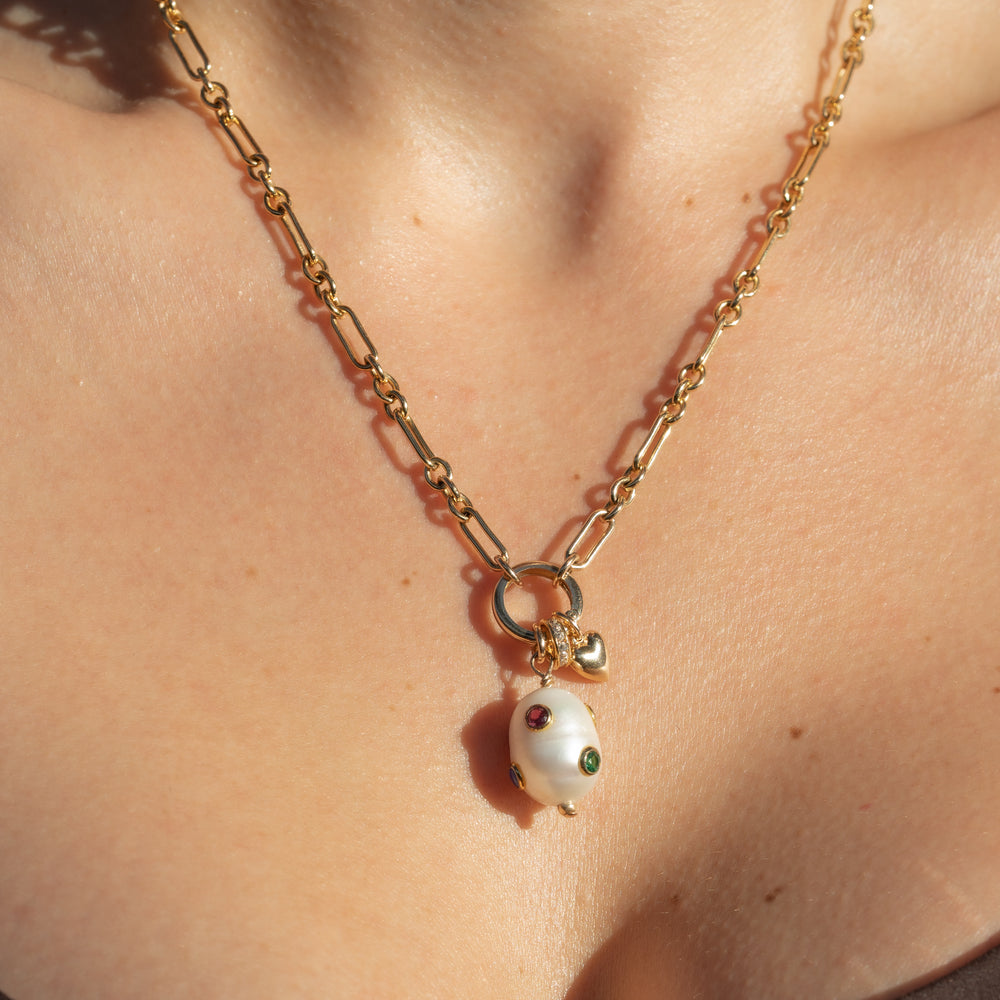 person wearing long and short chain with pearl drop charm, pave spacer and puffed heart charm