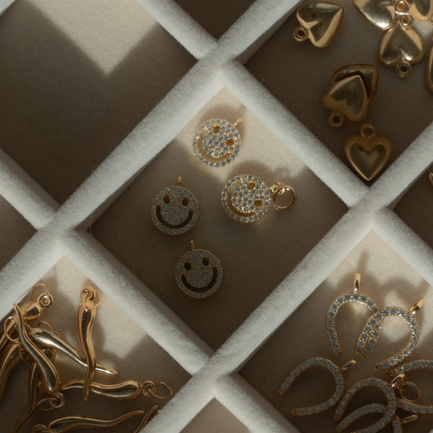 flat lay of pave smiley face charm on a jewelry tray 