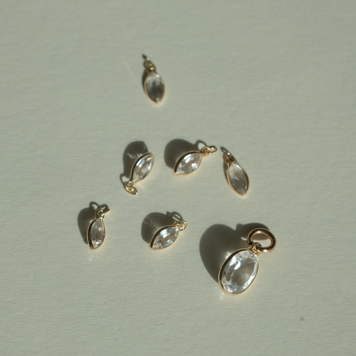 Gold Oval Topaz Charms on a light gray background