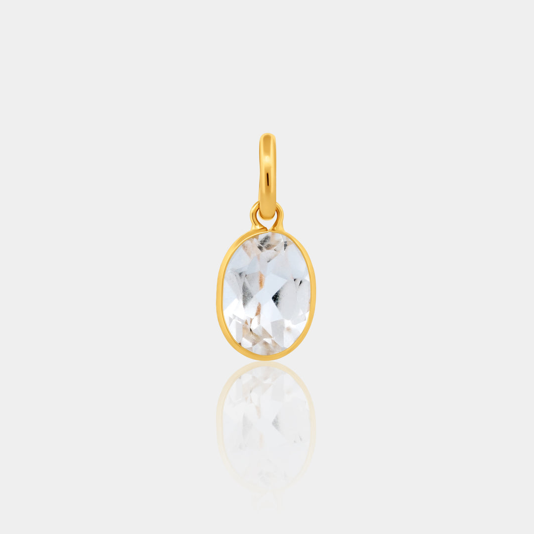 Gold Oval Bezel Set pendant with a clear gemstone on a light gray background