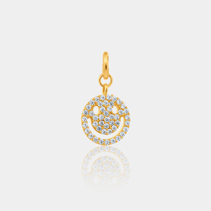 Gold smiley face pendant with clear stones on a light gray background
