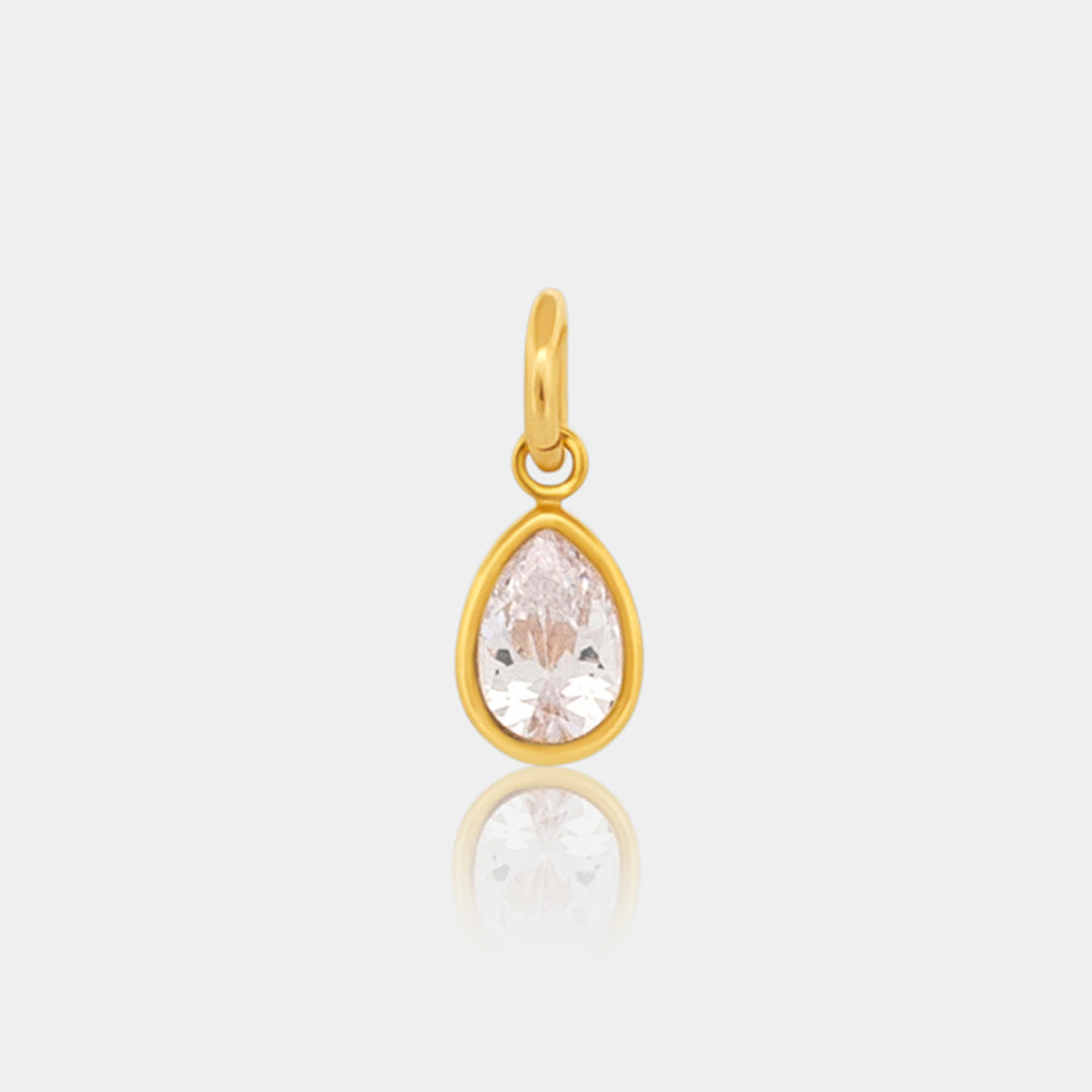 Gold pear shaped pendant with a clear gemstone on a light gray background