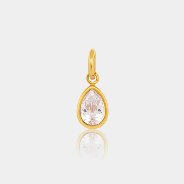 Gold pear shaped pendant with a clear gemstone on a light gray background