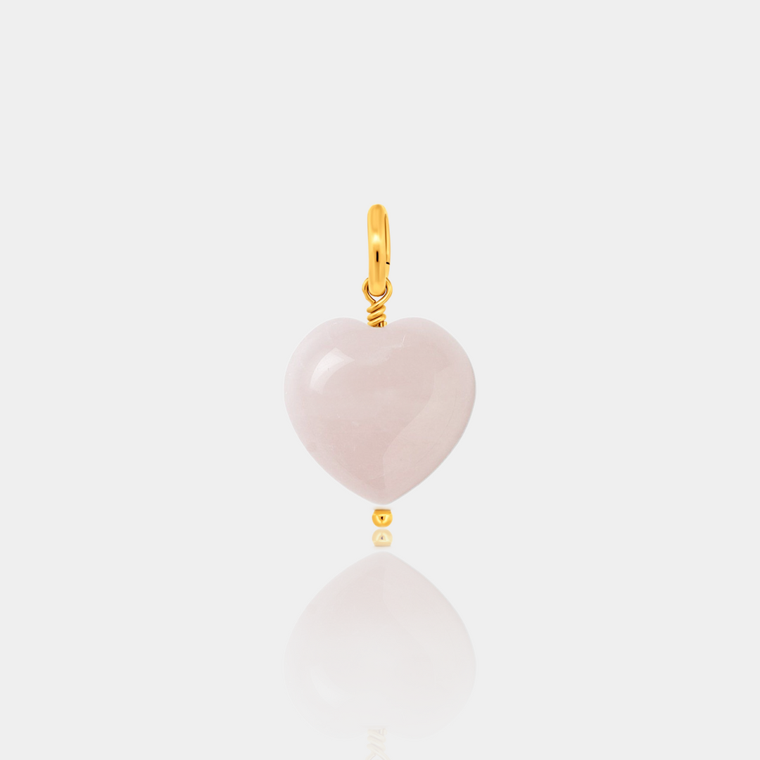Rose quartz heart-shaped pendant with gold-filled accents on a light gray background