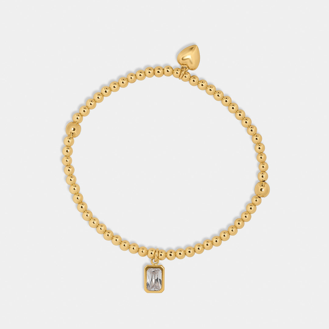gold bead bracelet with heart and emerald cut zirconia stone charm