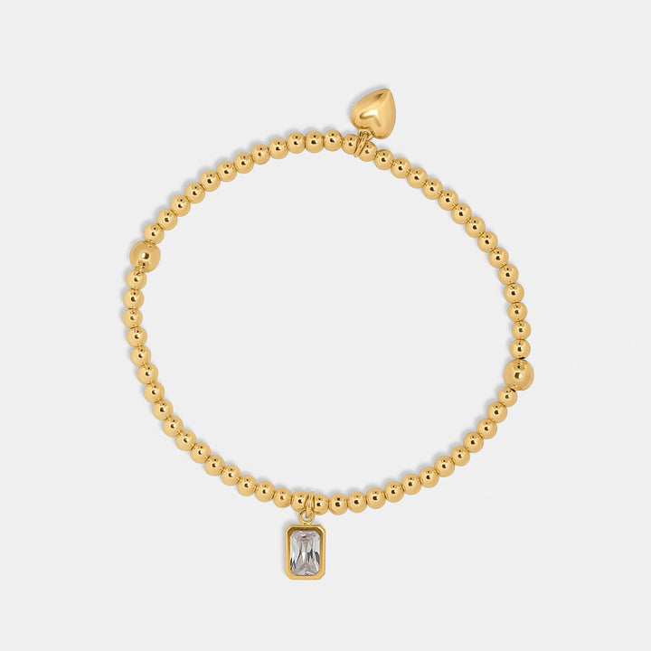 gold bead bracelet with heart and emerald cut zirconia stone charm