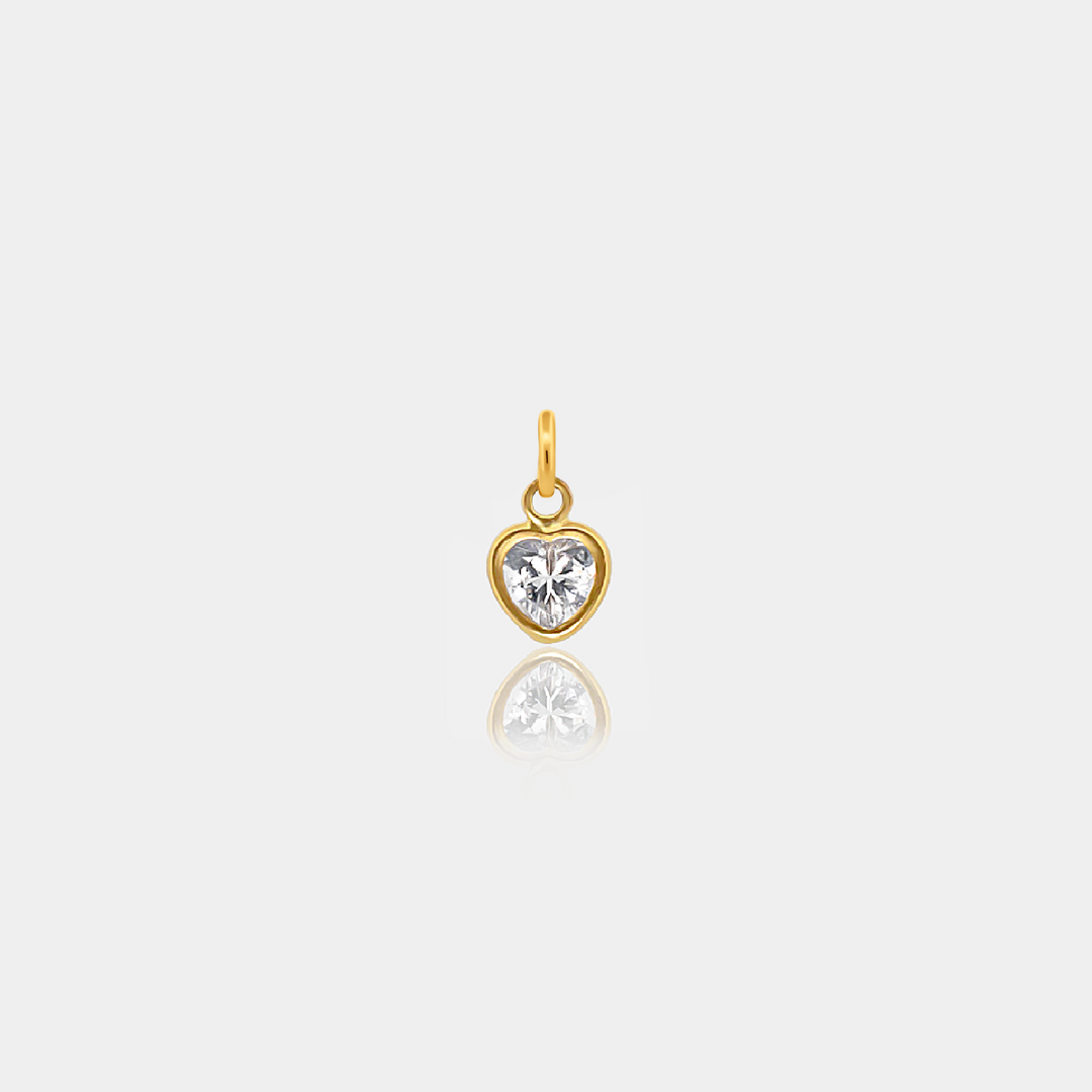 Gold -filled heart-shaped pendant with a clear gemstone on a light gray background