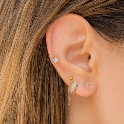 ear wearing crescent moon stud earrings 